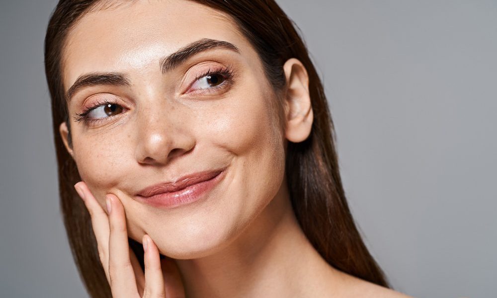 A,Young,Caucasian,Woman,Smiling,Warmly,With,Her,Hand,Elegantly Moxi Laser in Frederick, MD